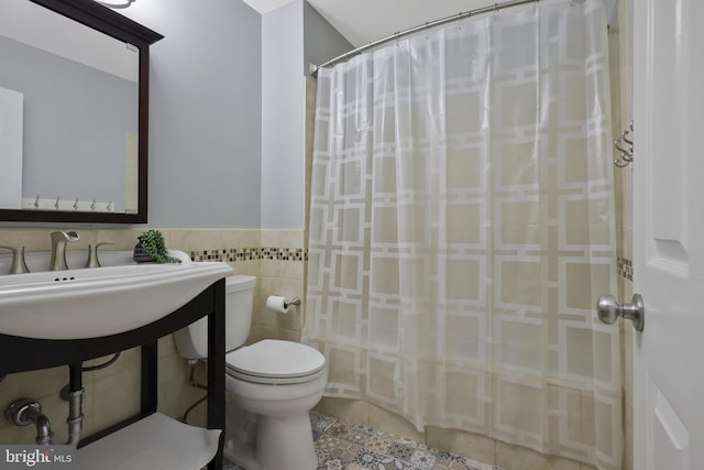 bathroom featuring tile patterned flooring, tile walls, curtained shower, and toilet