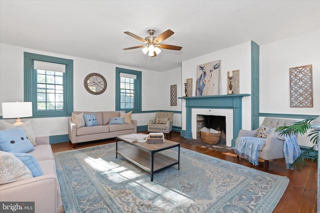 living room with dark hardwood / wood-style flooring, ceiling fan, and plenty of natural light