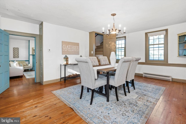 dining space featuring a chandelier, baseboard heating, and hardwood / wood-style floors