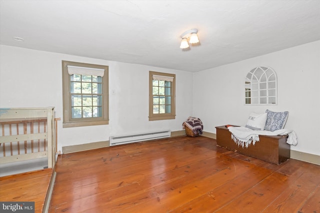 unfurnished room featuring baseboard heating and hardwood / wood-style flooring