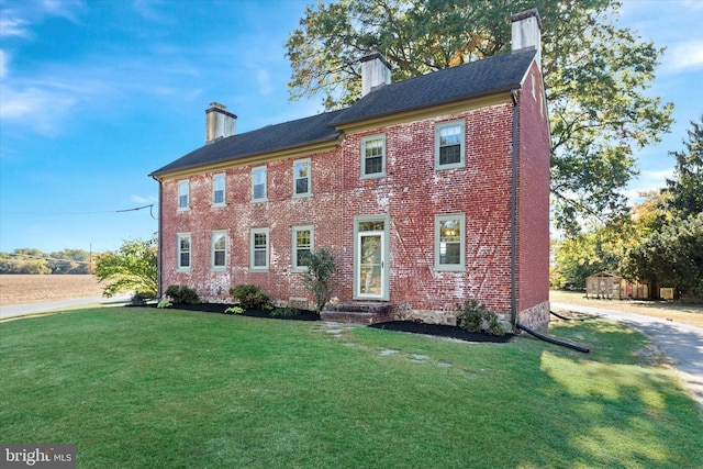 colonial home featuring a front lawn