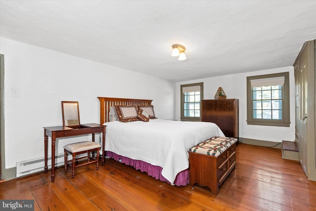 bedroom with a baseboard radiator and hardwood / wood-style floors