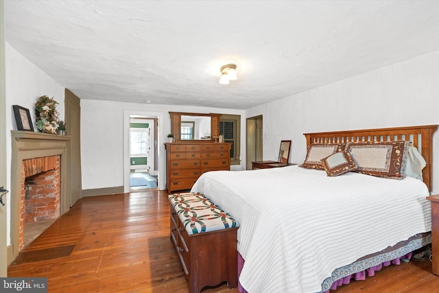 bedroom featuring hardwood / wood-style floors and a fireplace