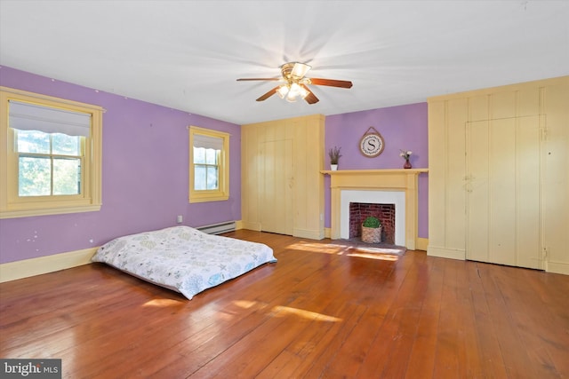 bedroom featuring a baseboard radiator, hardwood / wood-style floors, and ceiling fan