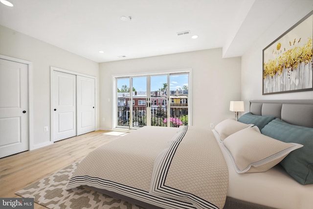 bedroom with a closet, light hardwood / wood-style flooring, and access to outside