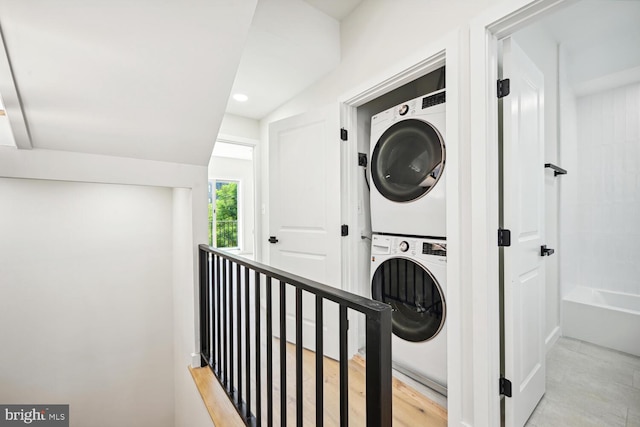 clothes washing area featuring stacked washer and clothes dryer