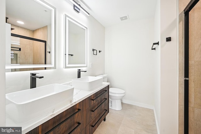 bathroom with vanity, toilet, tile patterned floors, and an enclosed shower