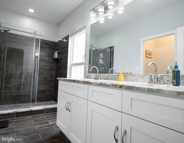 bathroom with vanity and a shower with door