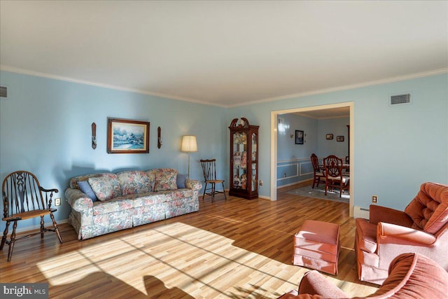 living room featuring hardwood / wood-style floors, baseboard heating, and ornamental molding