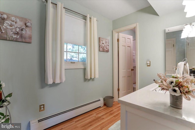 bathroom featuring wood-type flooring, vanity, and a baseboard heating unit