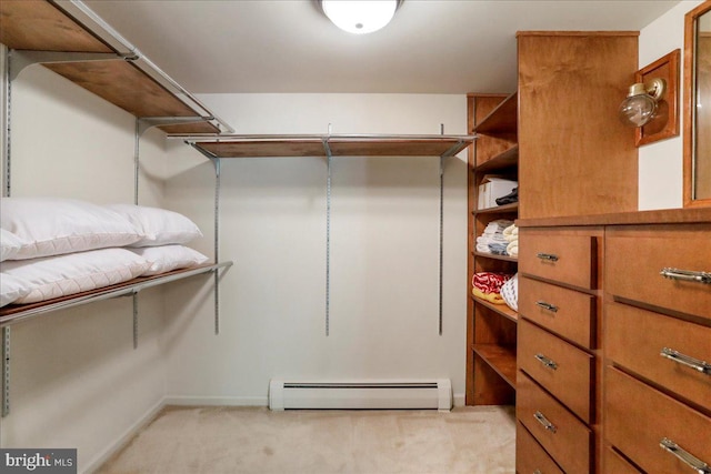 spacious closet featuring baseboard heating and light colored carpet