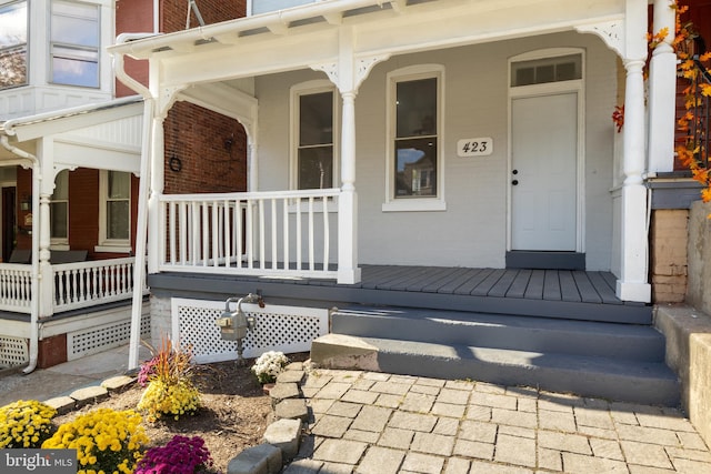 view of exterior entry featuring covered porch