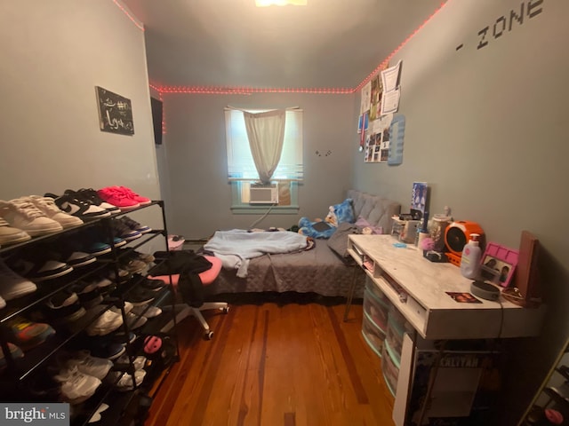 unfurnished bedroom featuring cooling unit and hardwood / wood-style floors