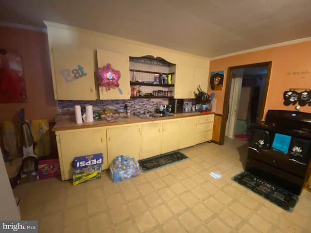 kitchen featuring crown molding, black range with gas cooktop, and decorative backsplash