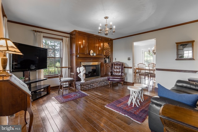 living room featuring a brick fireplace, dark hardwood / wood-style floors, an inviting chandelier, and ornamental molding