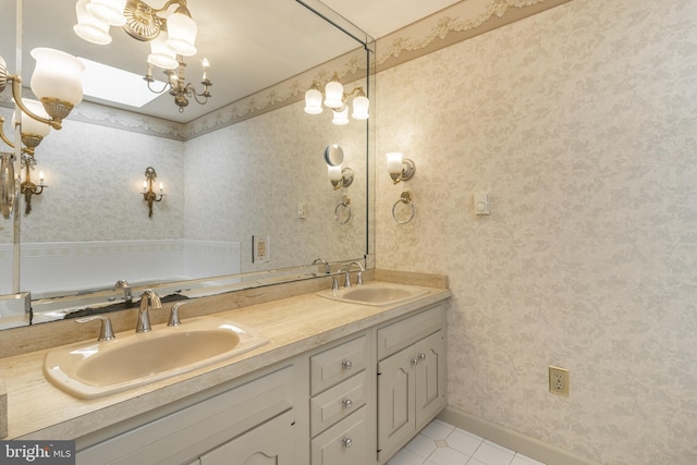 bathroom featuring vanity, a skylight, and tile patterned floors