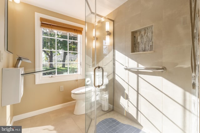 bathroom with tile patterned flooring, toilet, and a shower with shower door