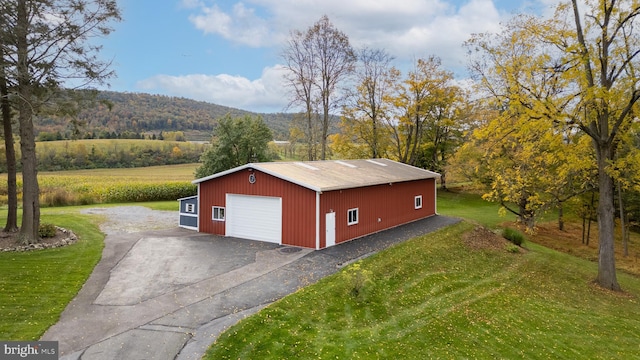 view of outbuilding with a mountain view, a garage, and a yard