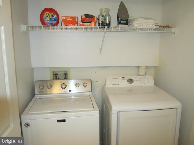 clothes washing area with washing machine and dryer