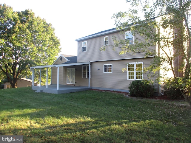 rear view of house featuring a yard