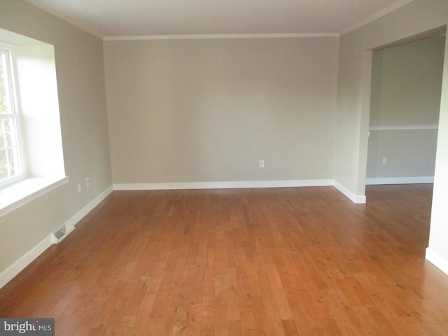 unfurnished room with crown molding and wood-type flooring