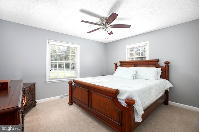 carpeted bedroom featuring a textured ceiling and ceiling fan