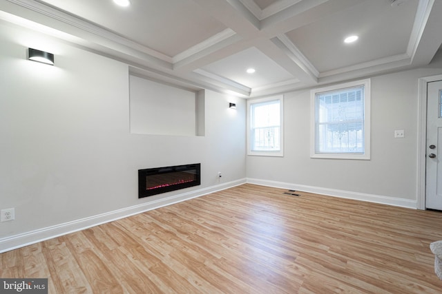 unfurnished living room featuring beamed ceiling, ornamental molding, coffered ceiling, and light hardwood / wood-style floors