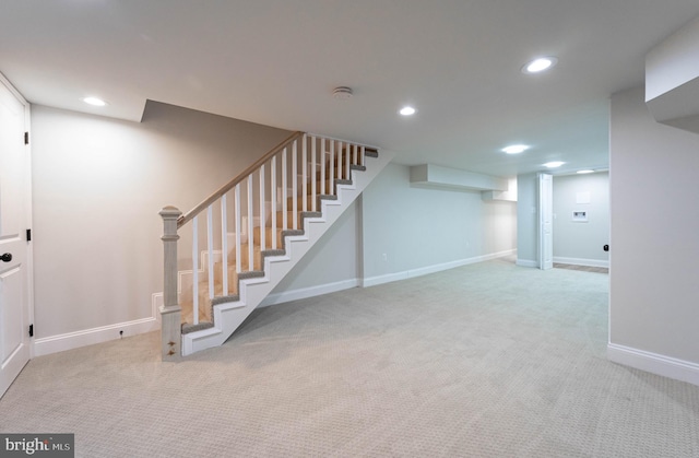 basement featuring light carpet