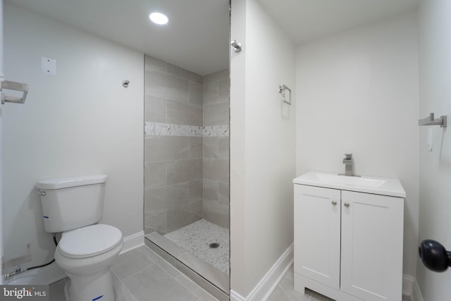 bathroom with vanity, a tile shower, and toilet