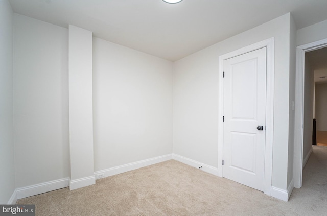 spare room featuring light colored carpet