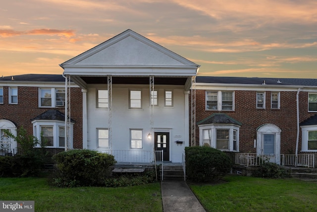 townhome / multi-family property featuring a yard