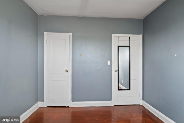 unfurnished room with dark wood-type flooring