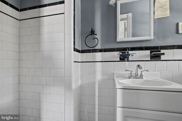 bathroom featuring vanity and tile walls