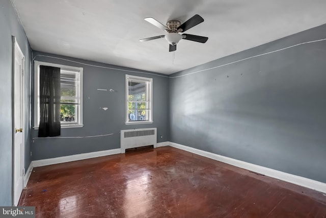 unfurnished room featuring ceiling fan, hardwood / wood-style flooring, and radiator