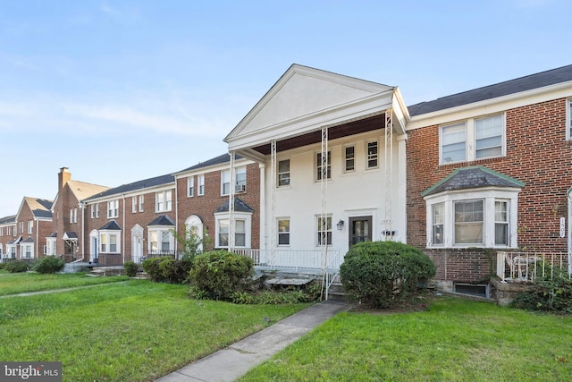 townhome / multi-family property featuring a front yard