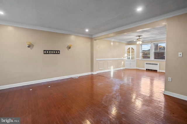 spare room with ceiling fan, hardwood / wood-style flooring, crown molding, and radiator heating unit