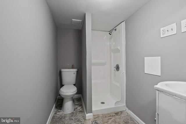 bathroom featuring toilet, walk in shower, and vanity