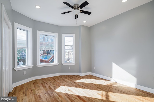 spare room with ceiling fan, light hardwood / wood-style floors, and a healthy amount of sunlight