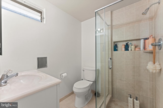 bathroom with tile patterned floors, vanity, a shower with door, and toilet