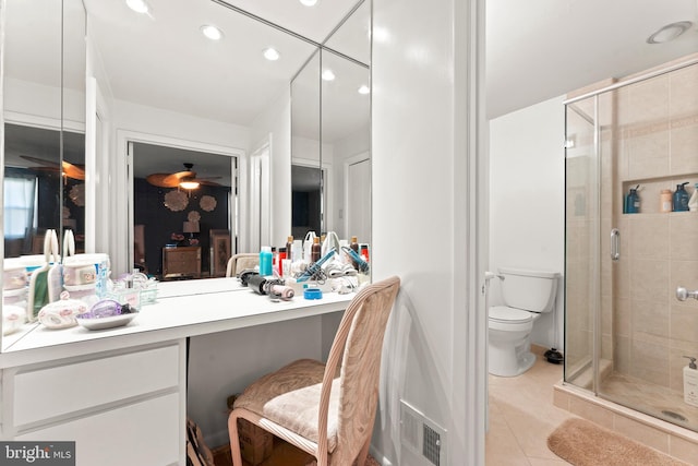 bathroom featuring tile patterned floors, vanity, toilet, and a shower with shower door