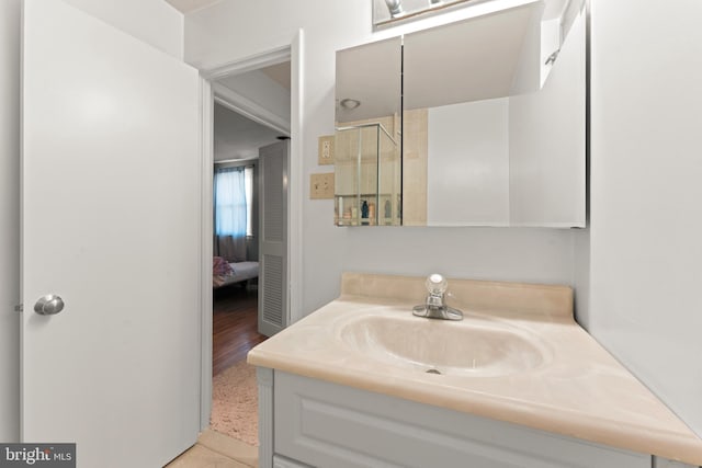 bathroom with an enclosed shower, hardwood / wood-style flooring, and vanity