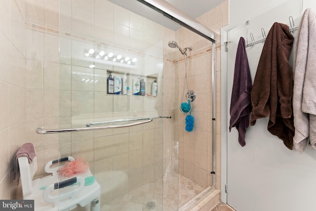 bathroom with a shower with shower door and toilet