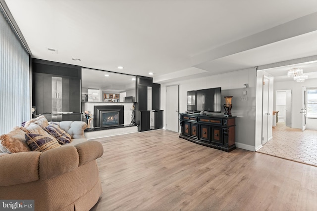 living room with light wood-type flooring and a chandelier