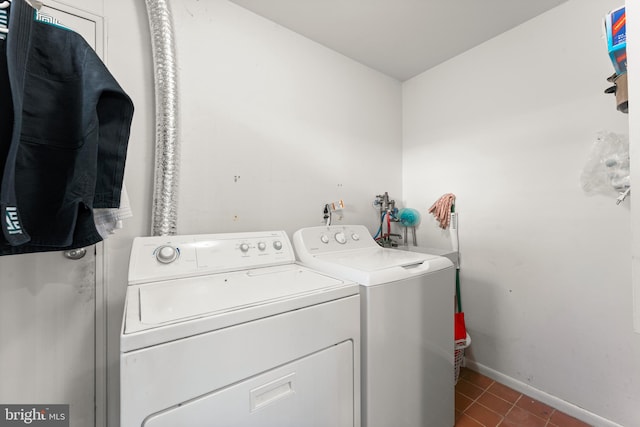 washroom featuring washer and clothes dryer and dark tile patterned floors