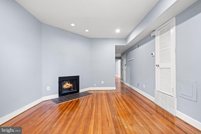 unfurnished living room featuring a fireplace and hardwood / wood-style flooring