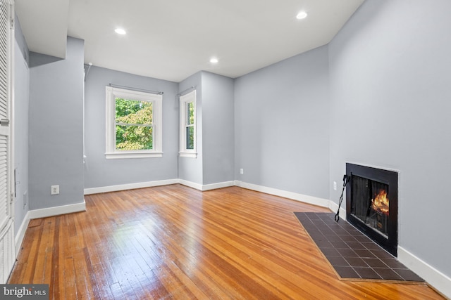 unfurnished living room with hardwood / wood-style flooring and a fireplace