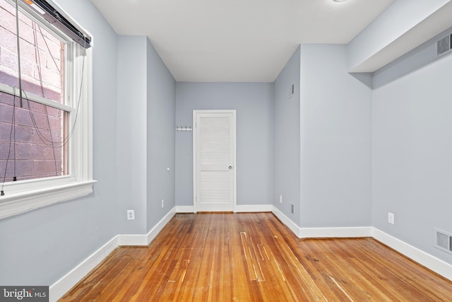 empty room with plenty of natural light and light hardwood / wood-style flooring