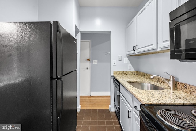 kitchen with dark hardwood / wood-style flooring, sink, light stone countertops, black appliances, and white cabinetry