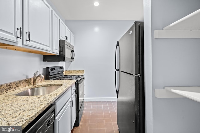 kitchen with black appliances, white cabinetry, sink, and light stone countertops