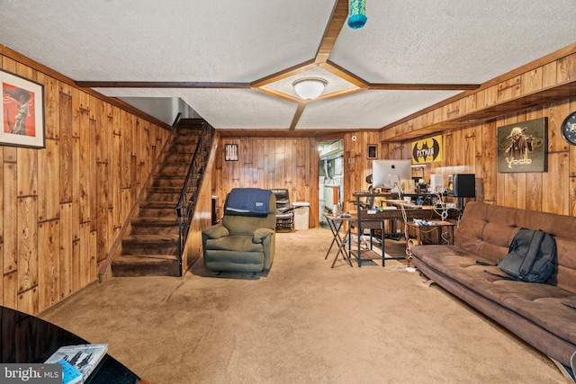 carpeted living room featuring wood walls, ornamental molding, beamed ceiling, and a textured ceiling